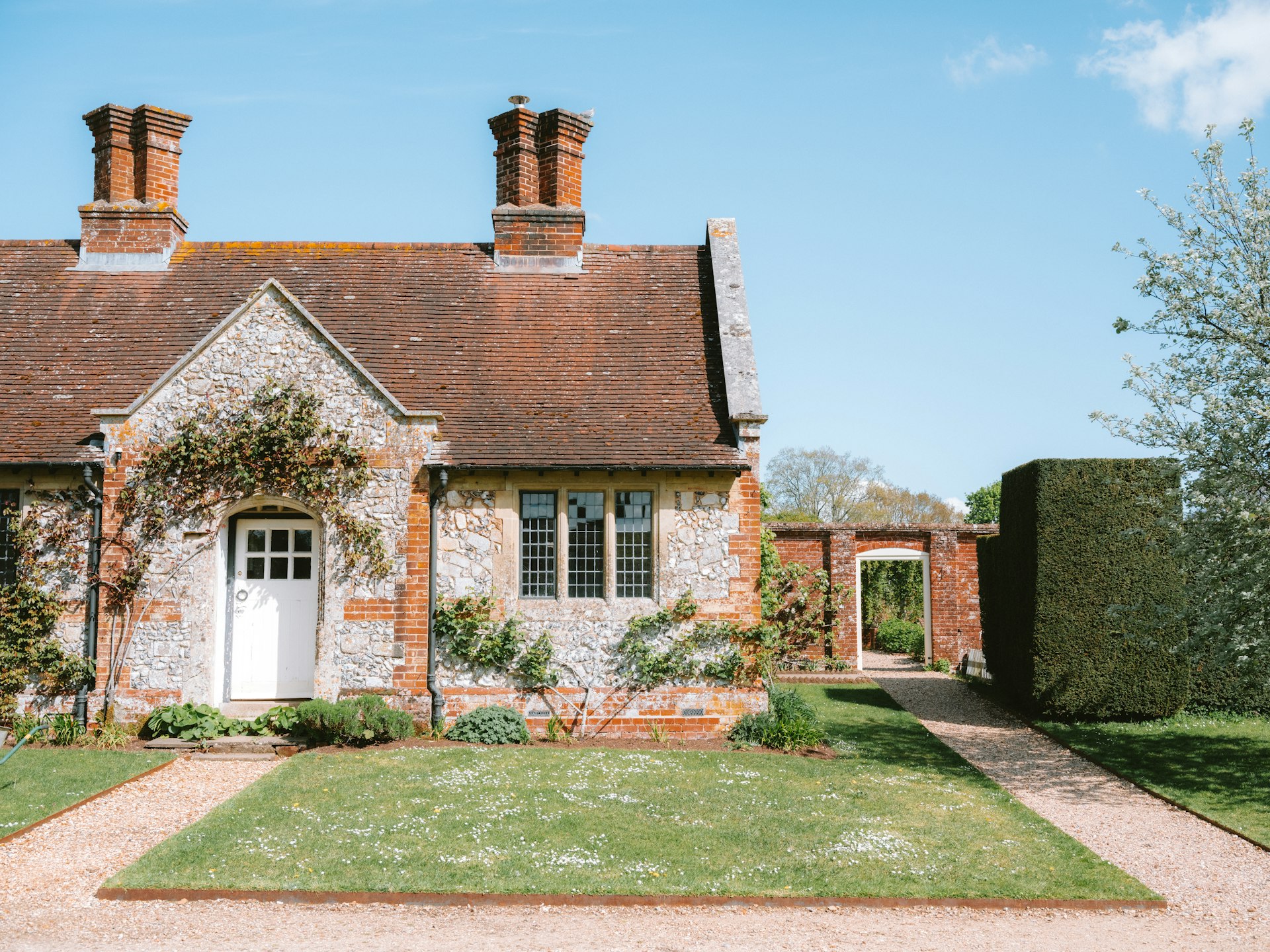 Charming stone cottage with garden path and blue sky